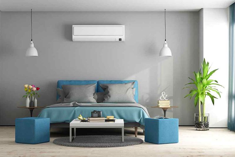 Climatiseur mural au-dessus d’un lit dans une chambre