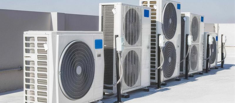 Rangée d’unités extérieures de pompes à chaleur sur un toit terrasse