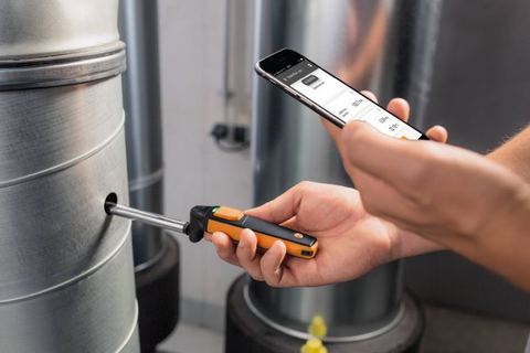 Sonde testo insérée dans une gaine de ventilation, mesure lue sur smartphone