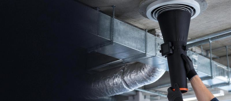 Cône de mesure de débit appliqué sur une bouche de soufflage, gaines de ventilation au plafond