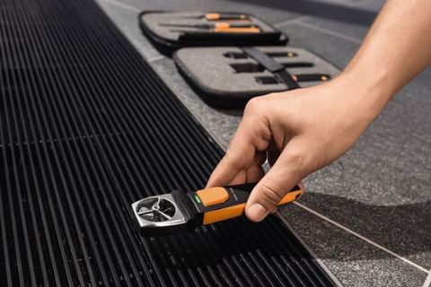 Anémomètre à hélice testo posé sur une grille de soufflage au sol